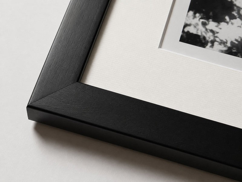 Juodo medinio rėmo, balto pasparto ir fotografijos detalė iš FOTOGRAFISTA Bottega puslapio.